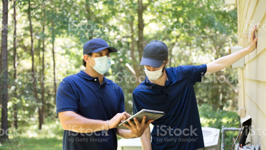 Two workers inspecting exterior of the house