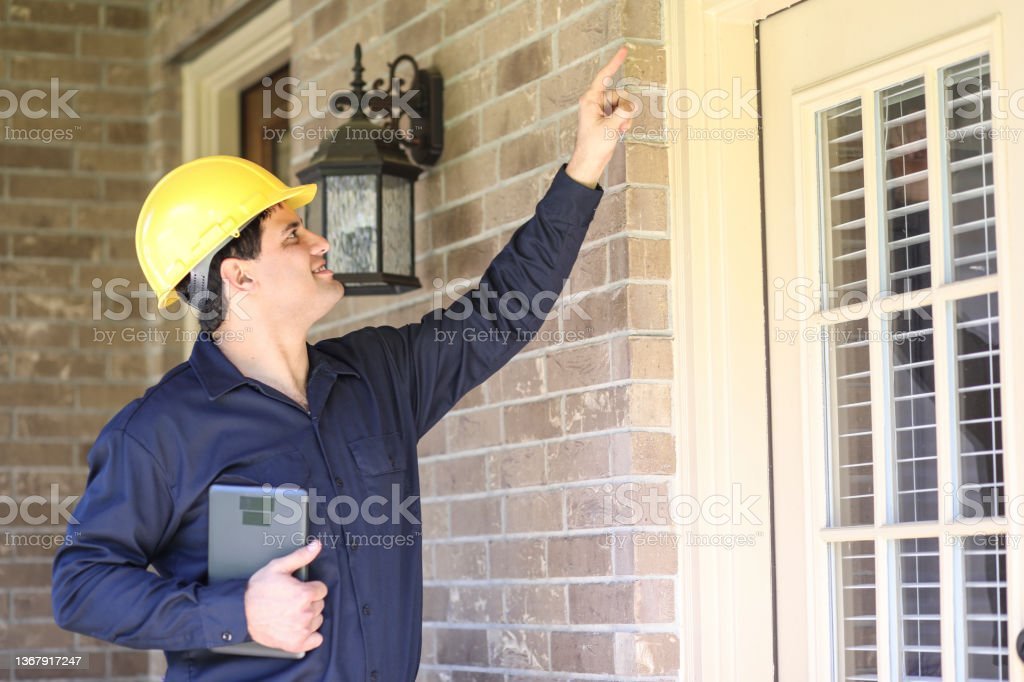 man inspects home exterior
